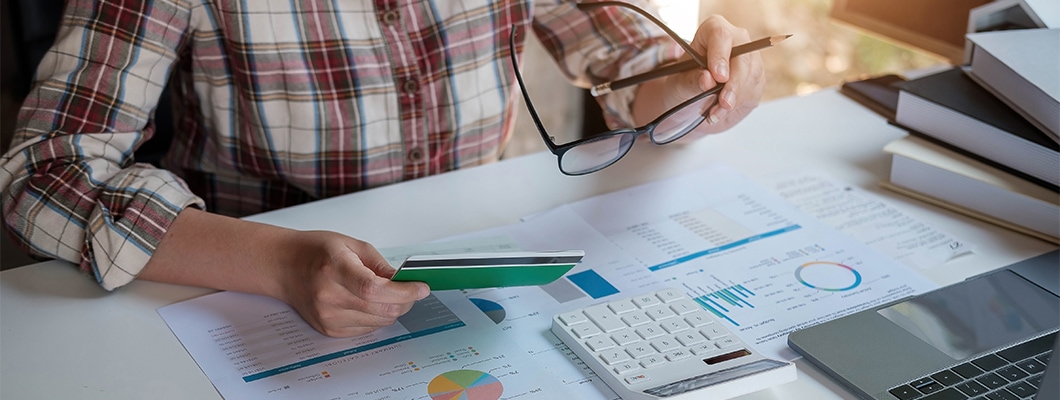 Person analyzing debt, considering IndusInd Bank's personal loan for debt consolidation based on low rates and easy process.